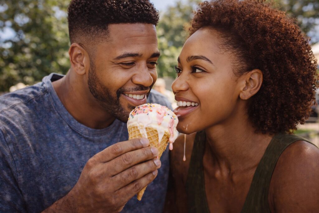 Zaya and Luca Haunsby smiling and sharing an ice cream outdoors